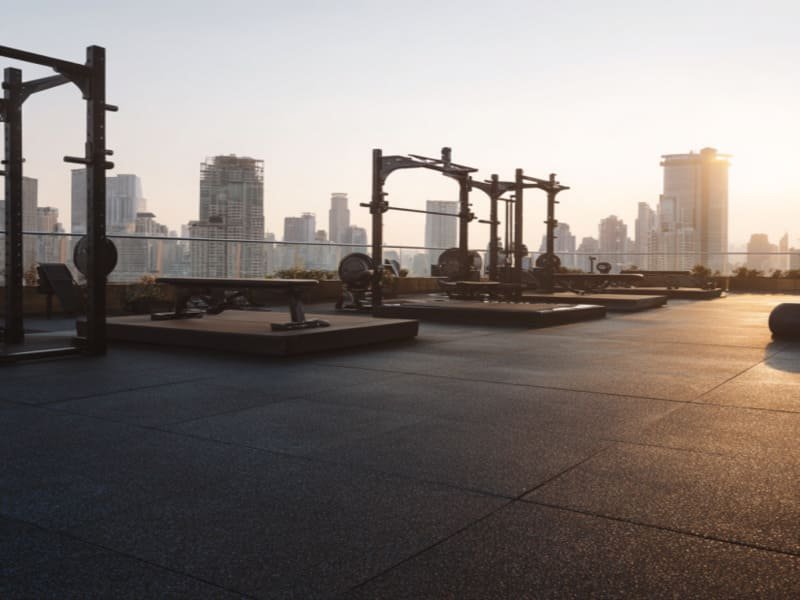 Ein Bauarbeiter verdichtet einen Schotterunterbau für eine Fliesenverlegung im Freien.